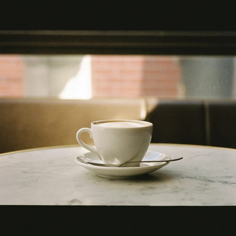 Cappuccino in a white cup on a marble table